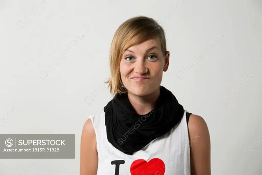Woman grimacing against white background