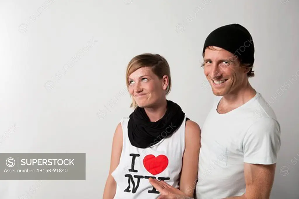 Couple standing against white background, smiling