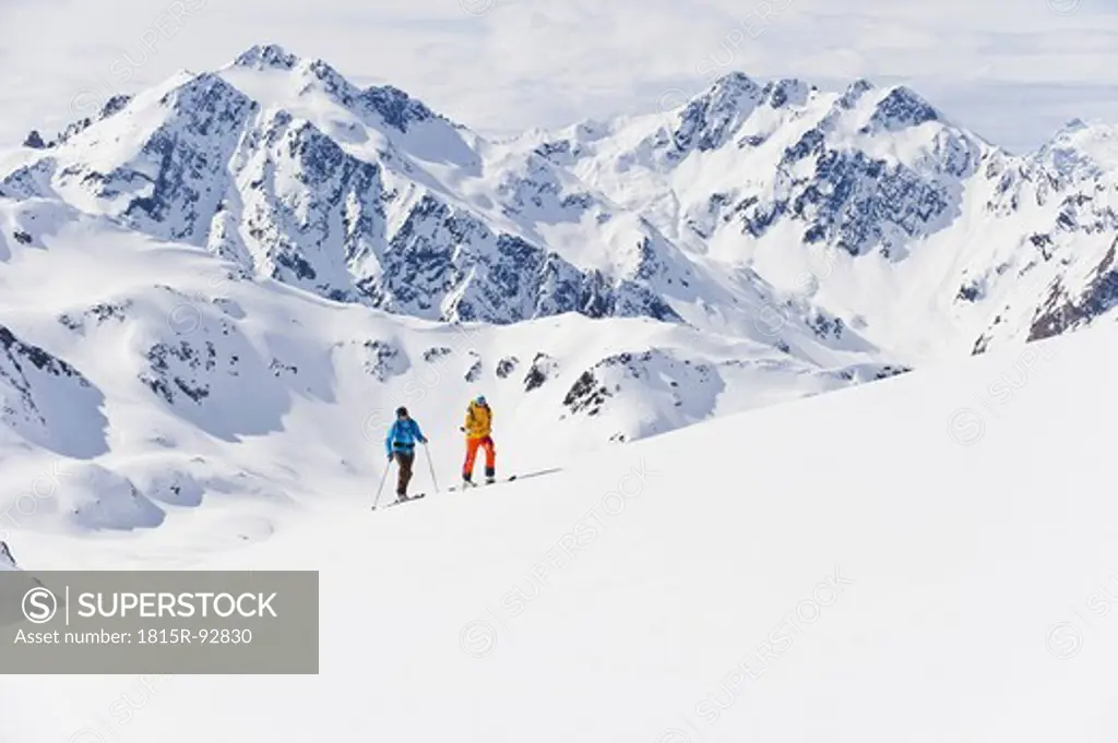 Austria, Stuben, Young couple doing telemark skiing on arlberg mountain