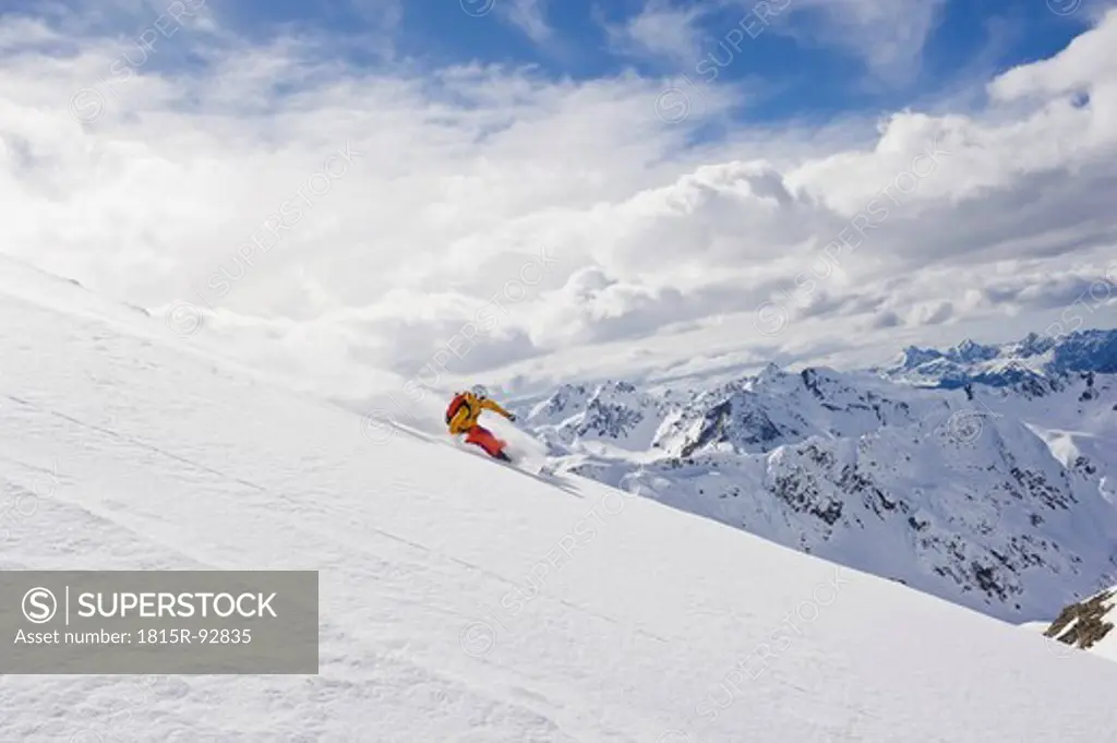 Austria, Stuben, Young woman telemark skiing on arlberg mountain
