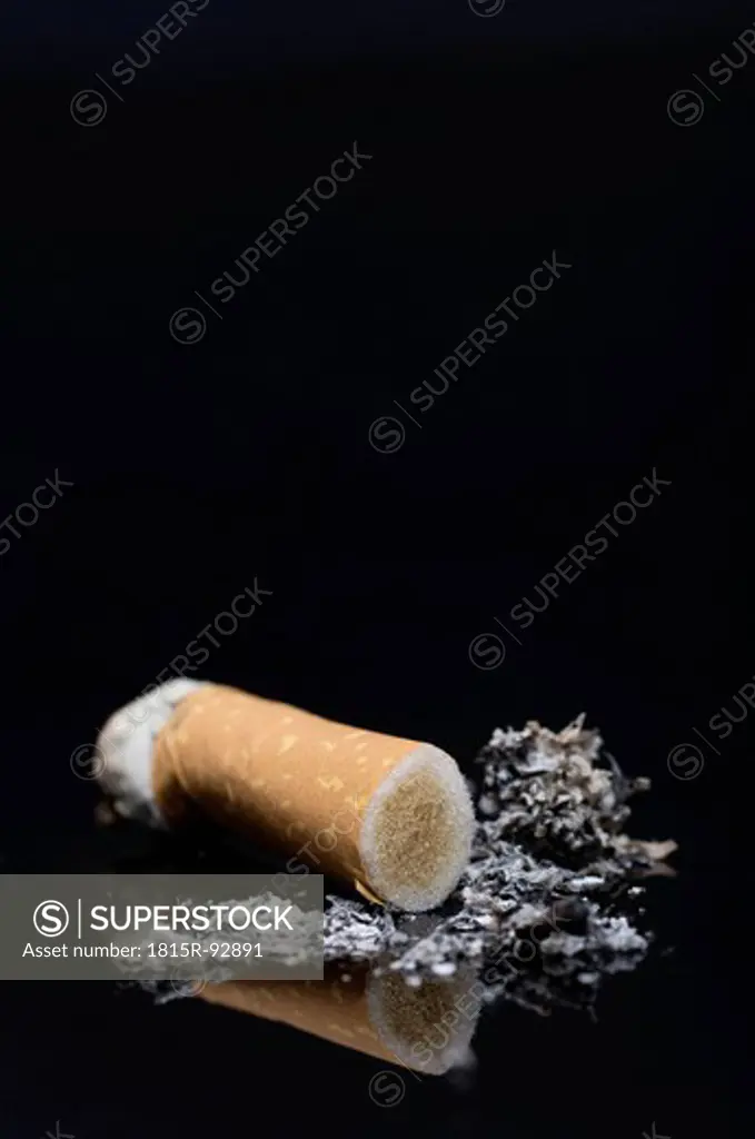 Burnt cigarette with ash on black background, close up