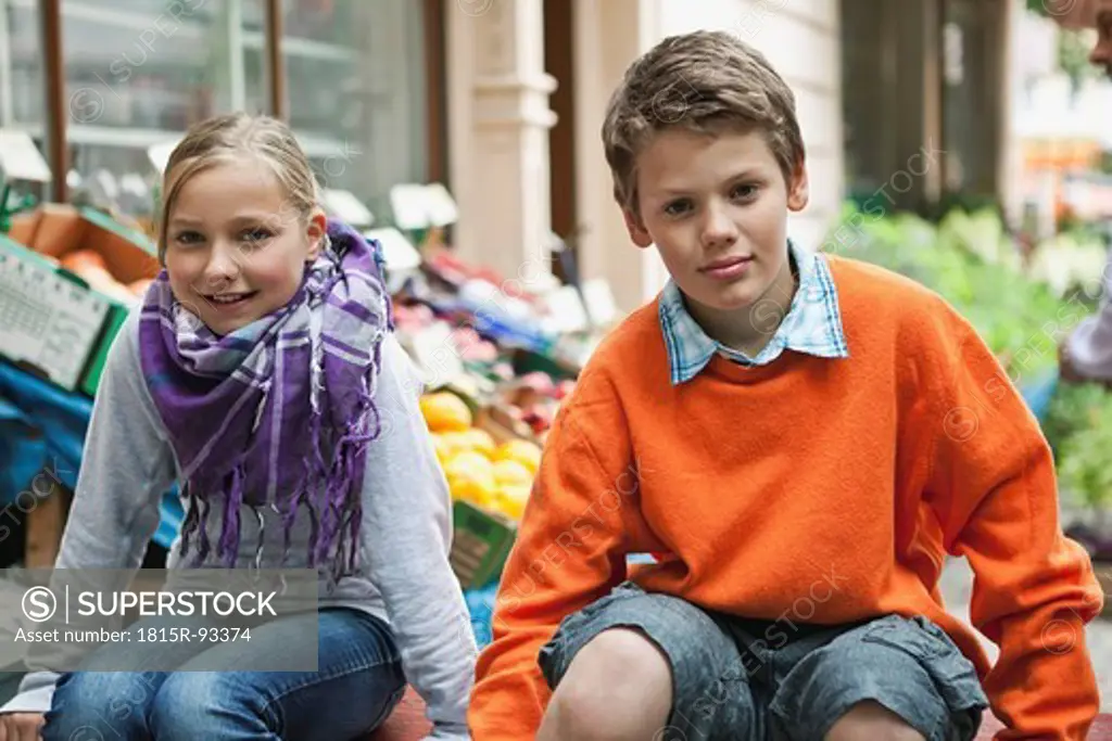 Germany, Berlin, Boy and girl at vegetable market