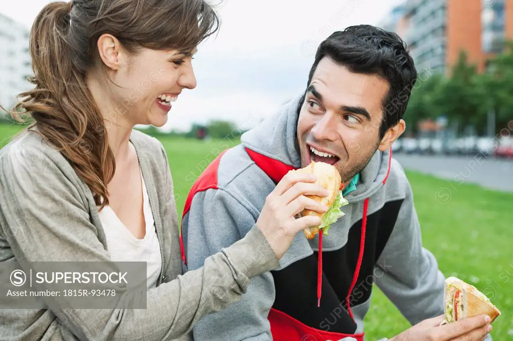 Germany, Berlin, Couple eating food in park