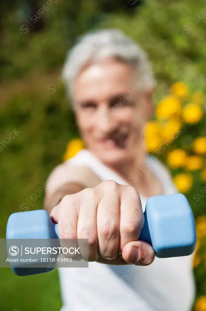 Germany, Bavaria, Mature man doing exercise with dumbbells