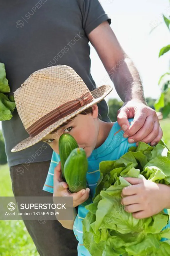 Germany, Bavaria, Grandfather with grandson in vegetable garden, smiling