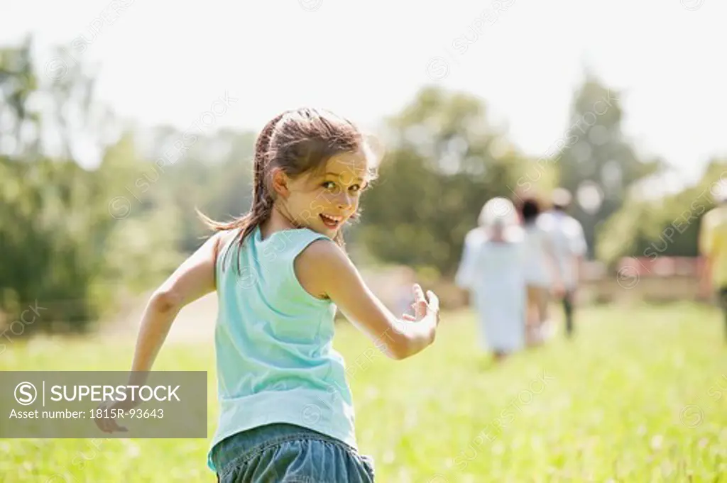 Germany, Bavaria, Girl running with family in background