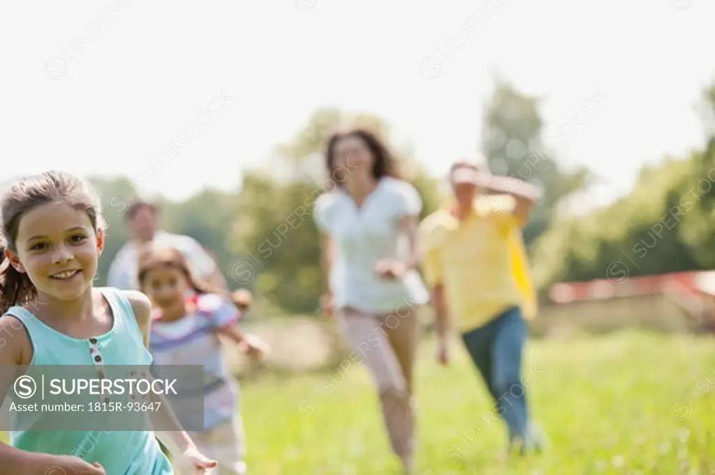Germany, Bavaria, Family running together in grass at picnic