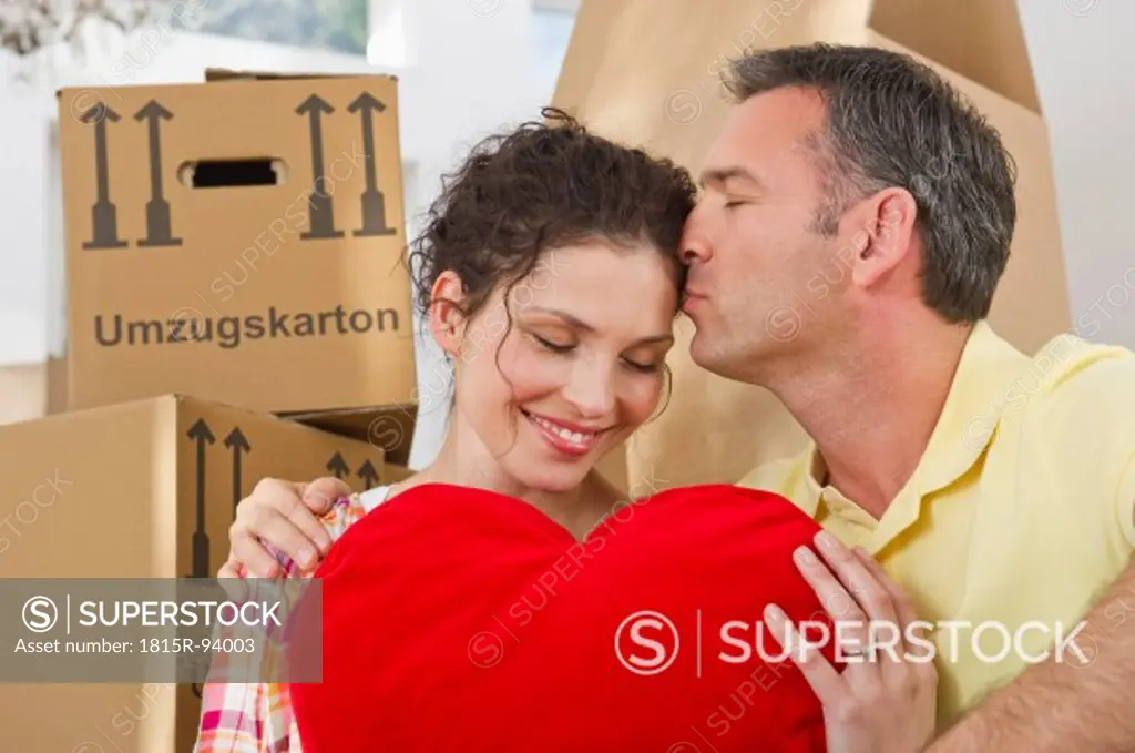 Germany, Bavaria, Grobenzell, Man kissing on forehead of woman in house