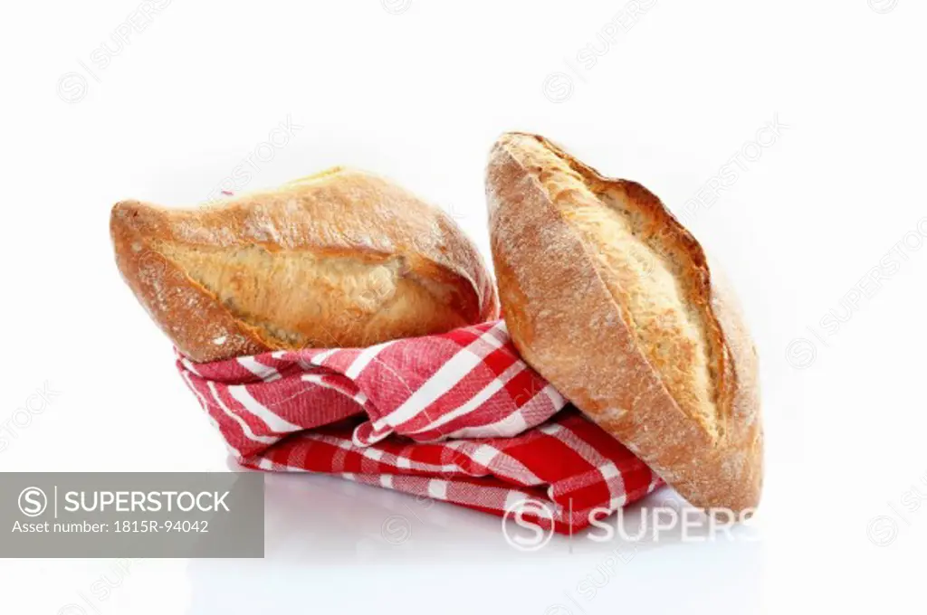 Baguette roll with kitchen towel on white background