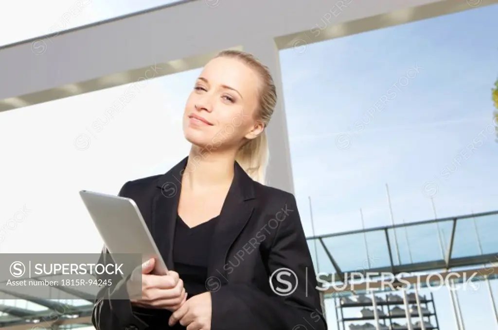 Germany, Bavaria, Munich, Businesswoman with digital tablet, smiling, portrait