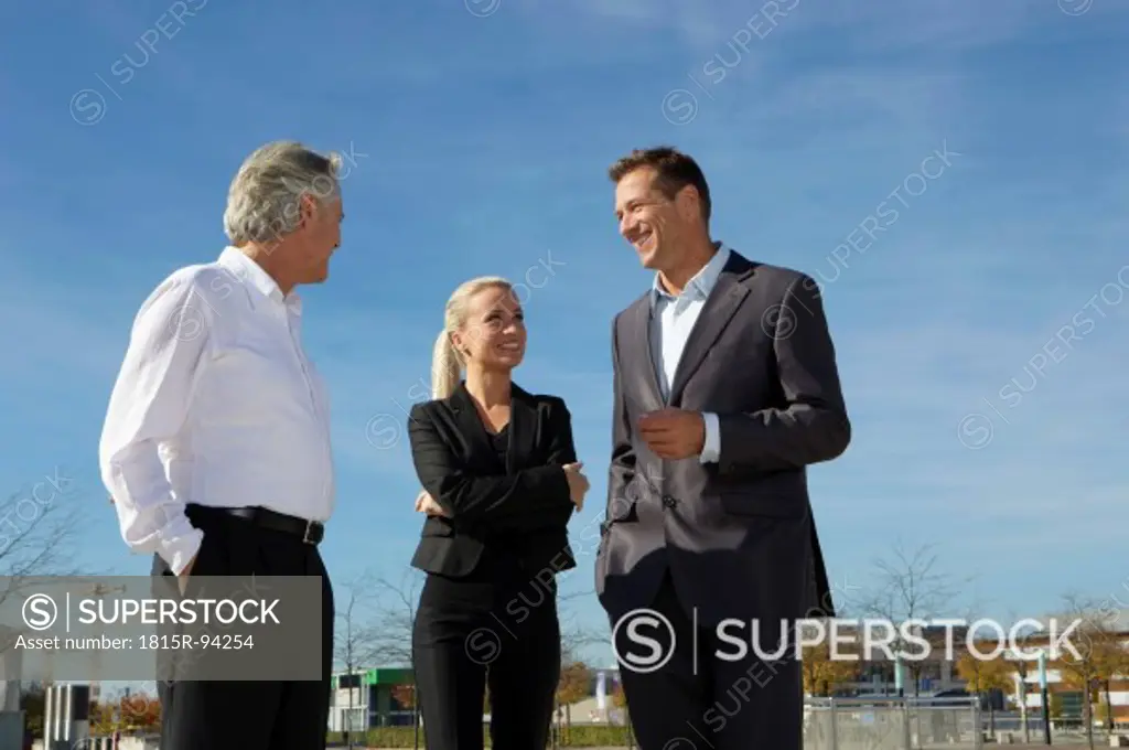 Germany, Bavaria, Munich, Business people standing against sky, smiling
