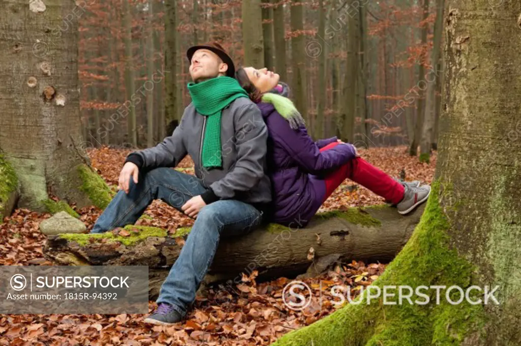 Germany, Berlin, Wandlitz, Couple sitting on tree trunk