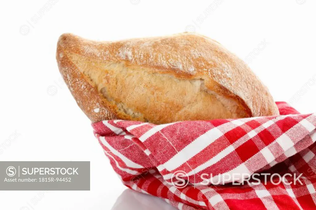 Baguette roll with kitchen towel on white background