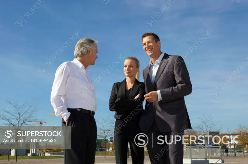 Germany, Bavaria, Munich, Business people standing against sky, smiling