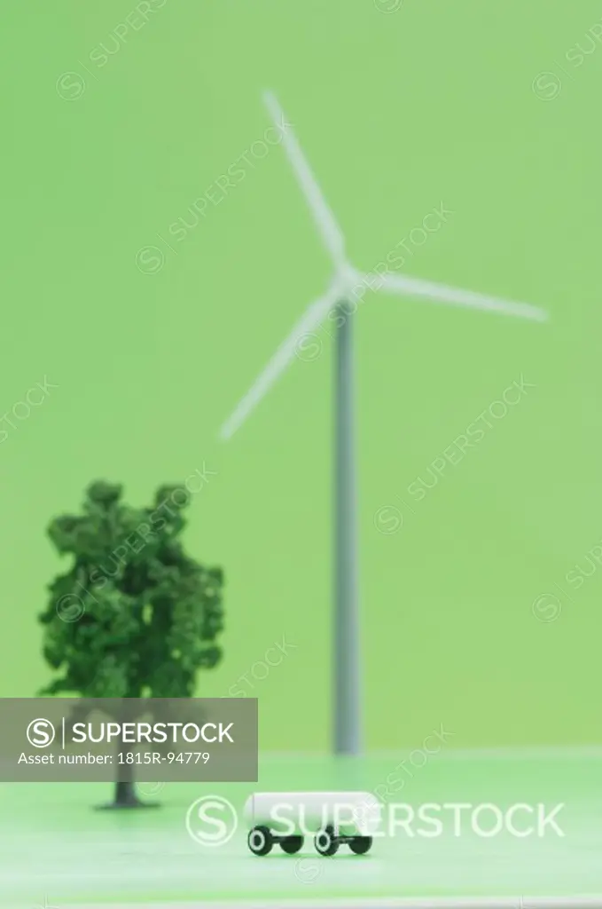 Battery on wheel and wind wheel against green background