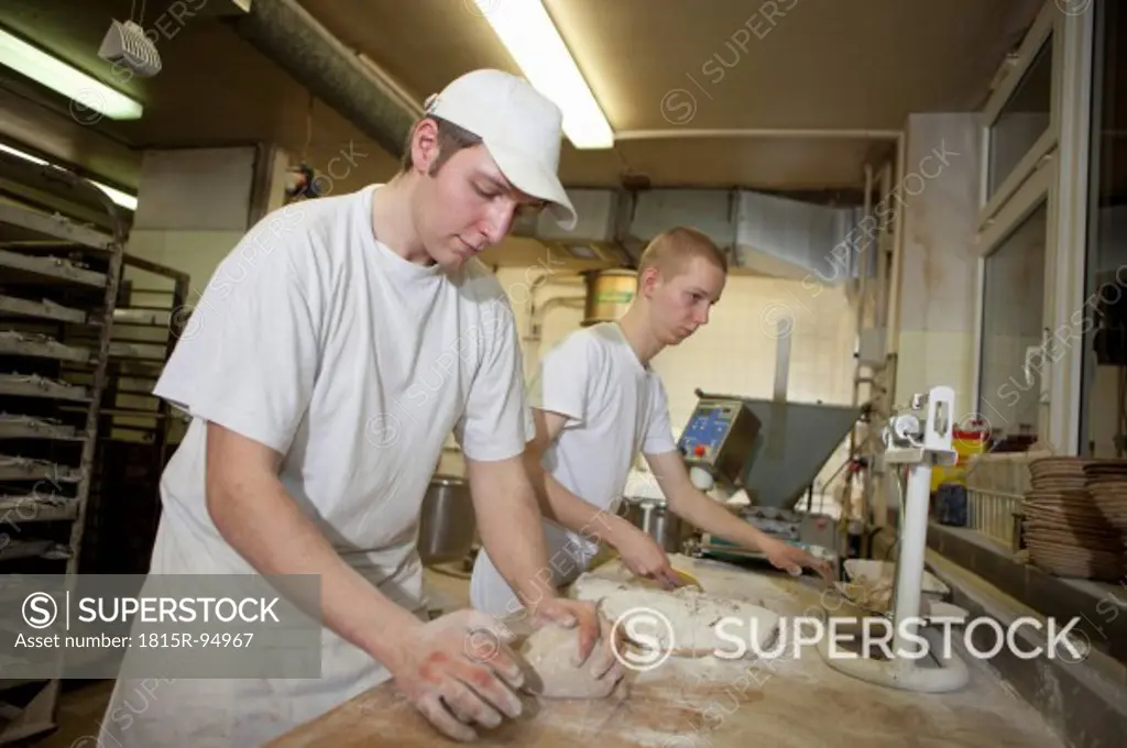 Germany, Bavaria, Munich, Bakers kneading dough
