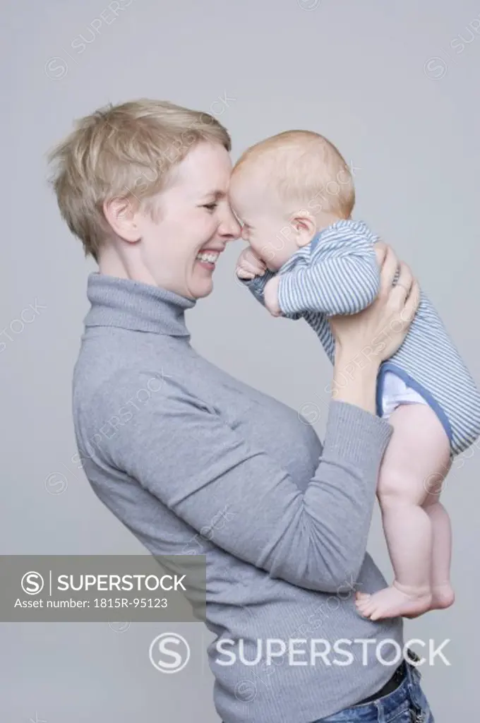 Mother holding baby boy, smiling