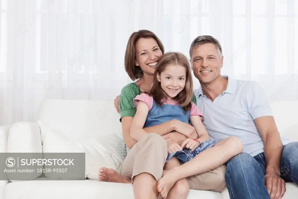 Germany, Munich, Family sitting on couch, smiling, portrait