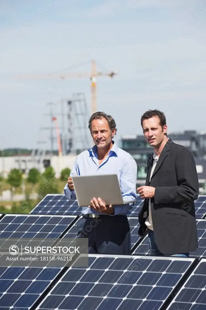 Germany, Munich, Engineer and man discussing in solar plant