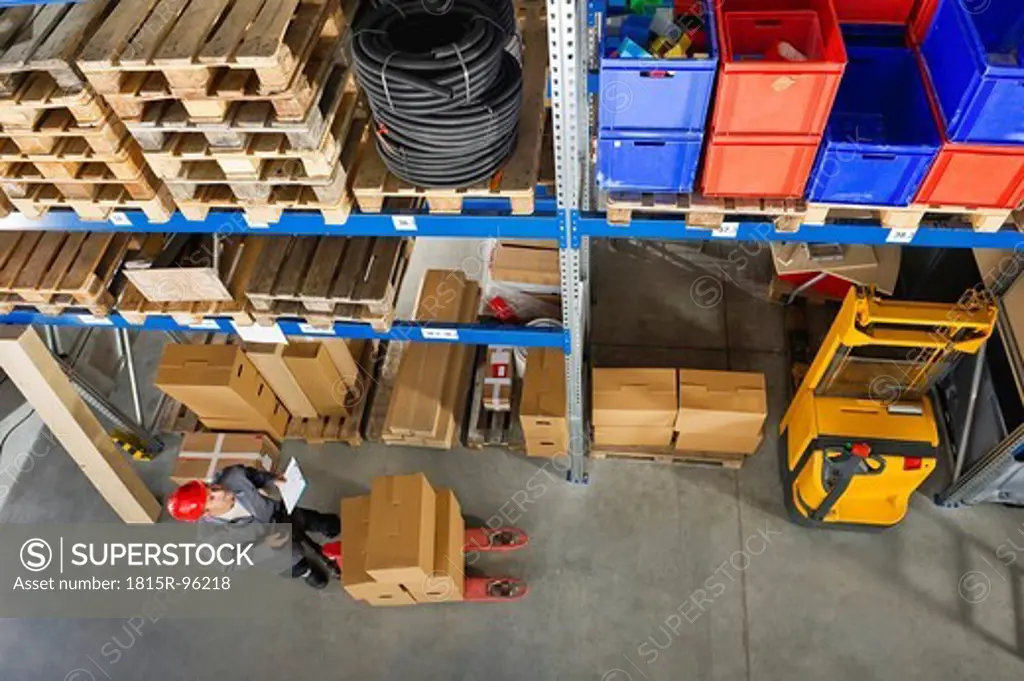 Germany, Bavaria, Munich, Manual worker with clipboard in warehouse
