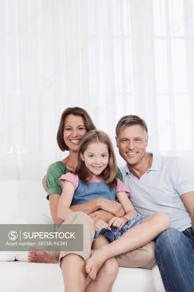 Germany, Munich, Family sitting on couch, smiling, portrait