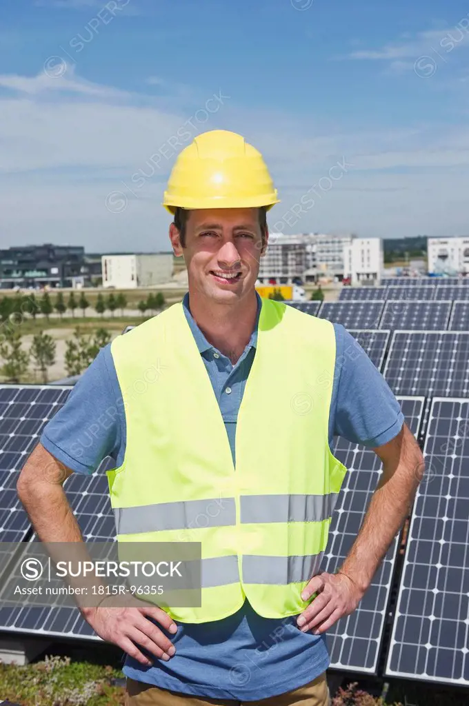 Germany, Munich, Technician in solar plant, smiling, portrait
