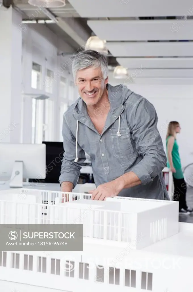 Germany, Bavaria, Munich, Man standing with architectural model in office