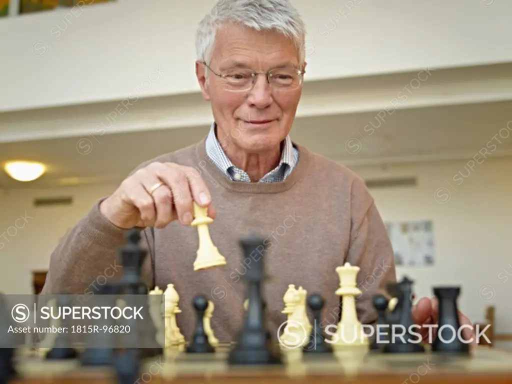 Germany, Cologne, Senior man playing chess in nursing home
