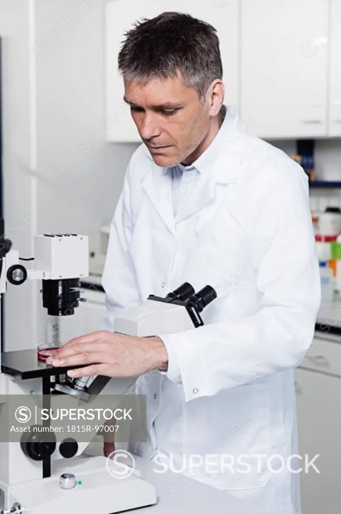 Germany, Bavaria, Munich, Scientist with microscope in laboratory