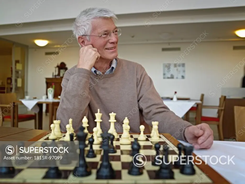 Germany, Cologne, Senior man playing chess in nursing home