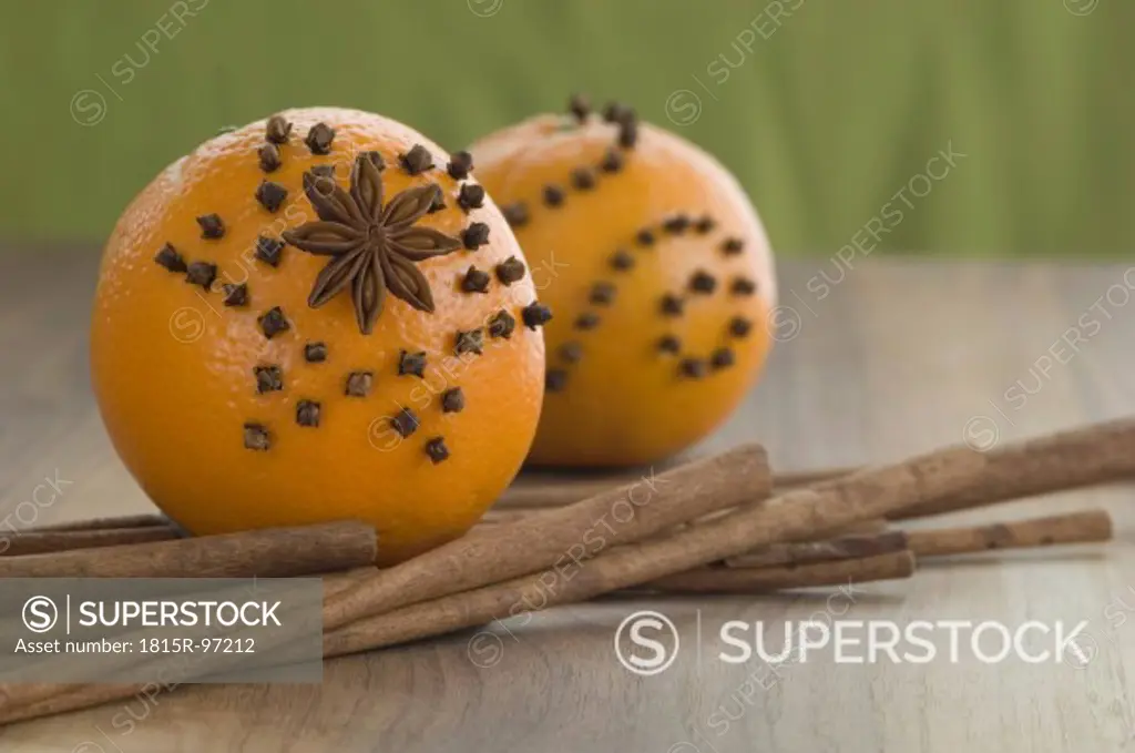 Orange studded with cloves and star anise, cinnamon stick on table