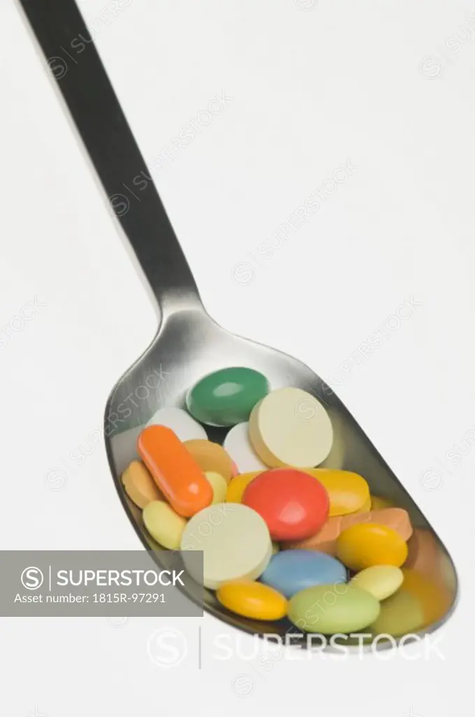 Medicines in spoon against white background