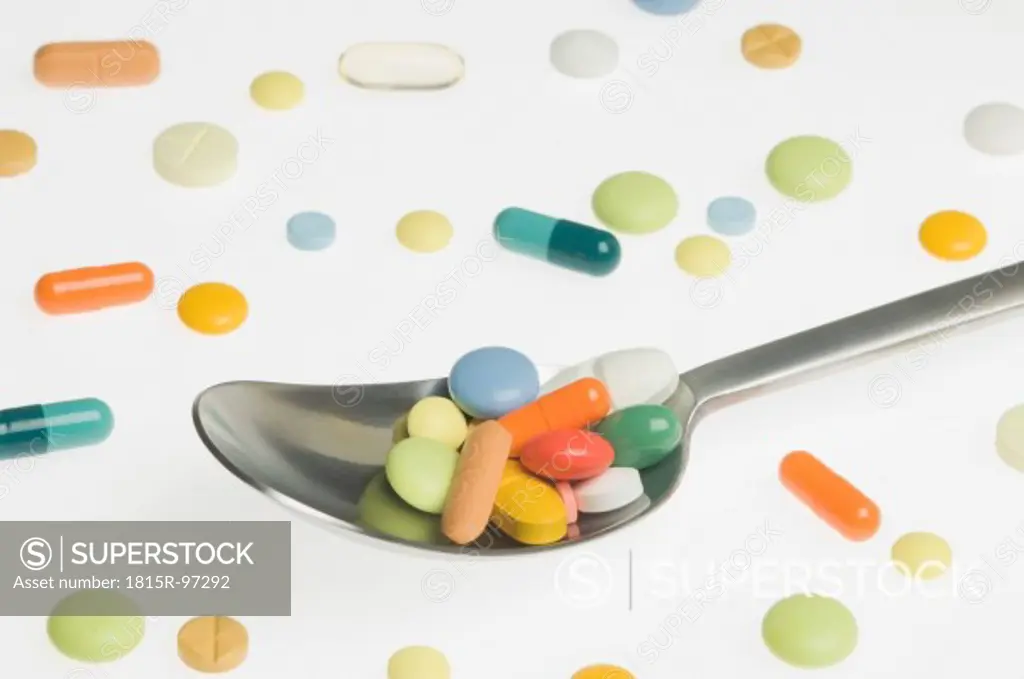 Medicines in spoon on white background