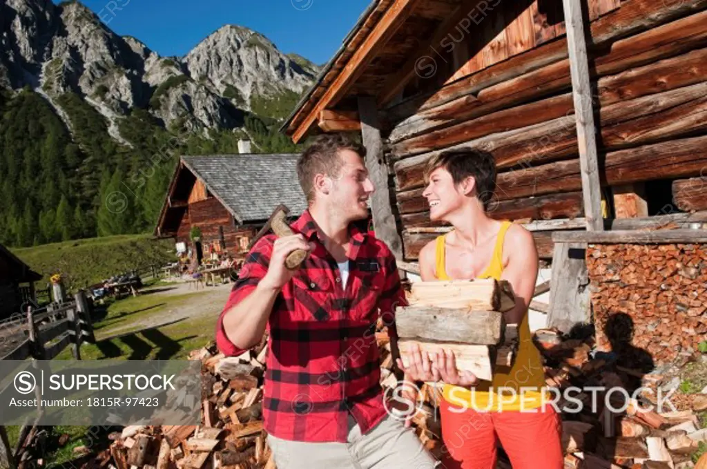 Austria, Salzburg County, Man and woman with chopped wood, smiling