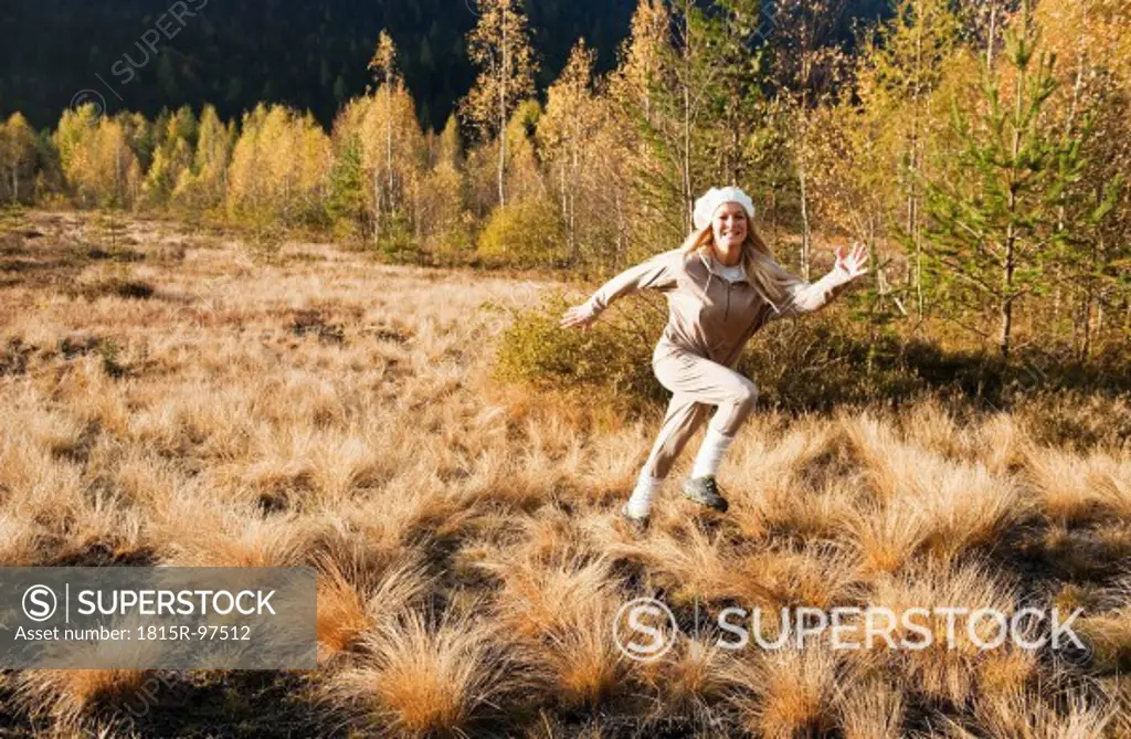 Austria, Salzburg, Young woman running in autumn