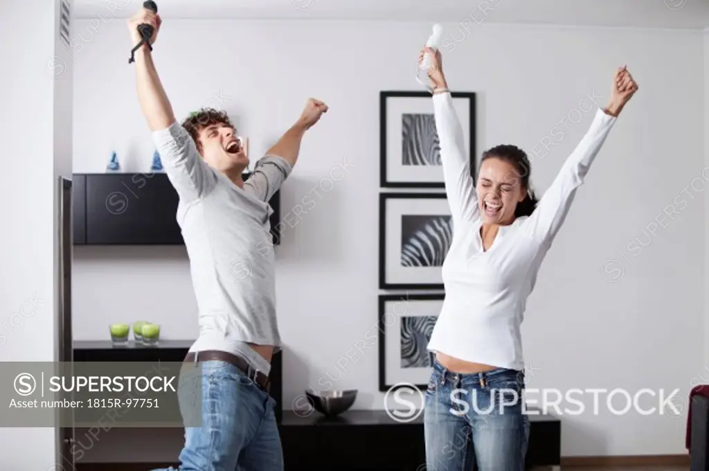 Germany, Bavaria, Young couple playing with game console