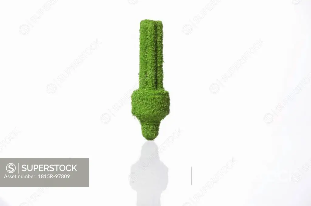 Energy efficient lightbulb covered with grass on white background
