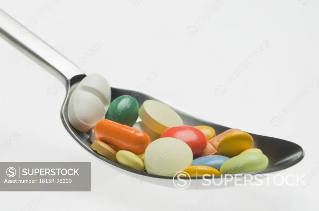 Medicines in spoon against white background
