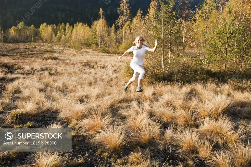 Austria, Salzburg, Young woman running in autumn