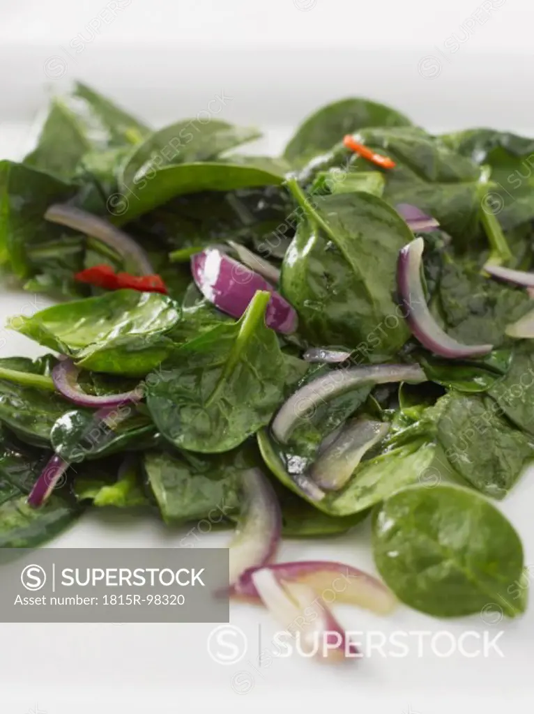 Spinach with red onion and olive oil, close up