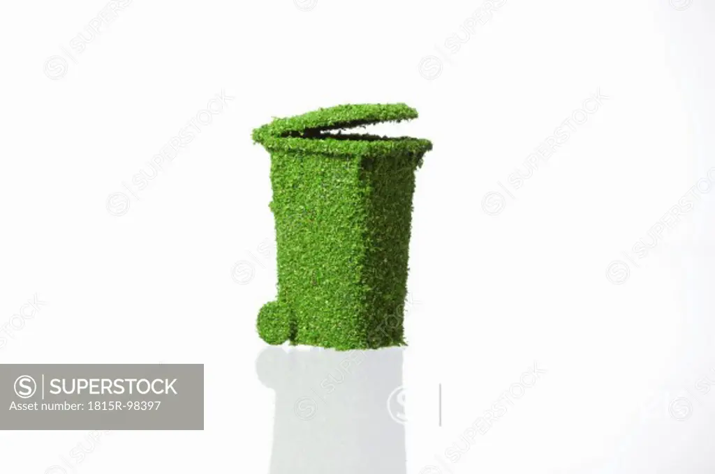 Rubbish bin covered with grass on white background