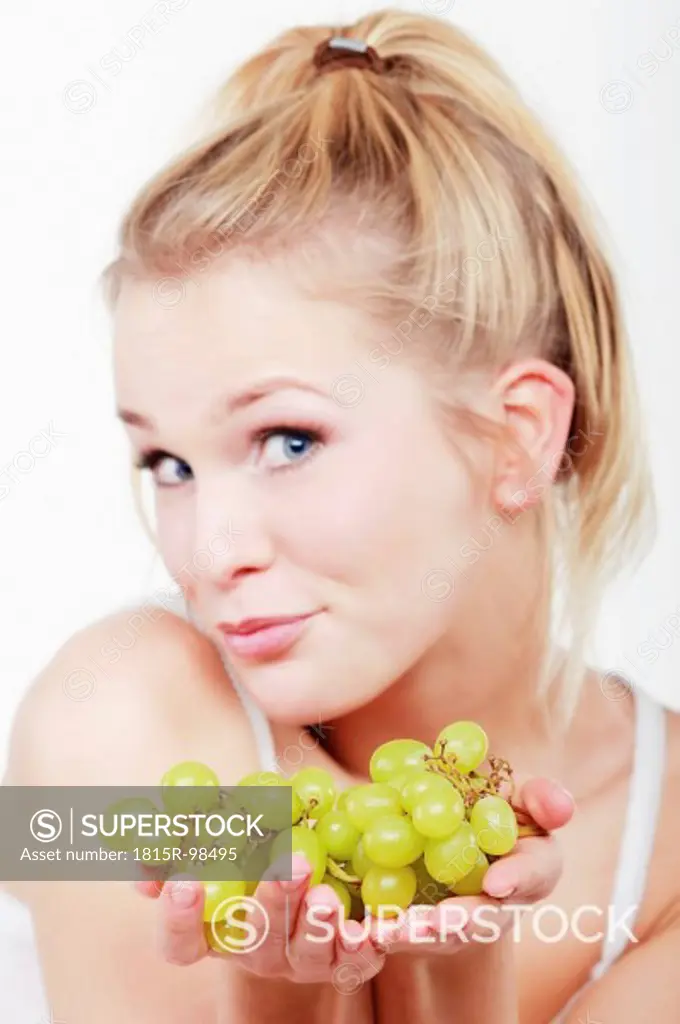 Young woman holding grapes, portrait