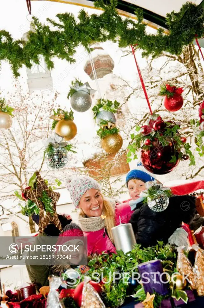 Austria, Salzburg, Mother with children at christmas market, smiling