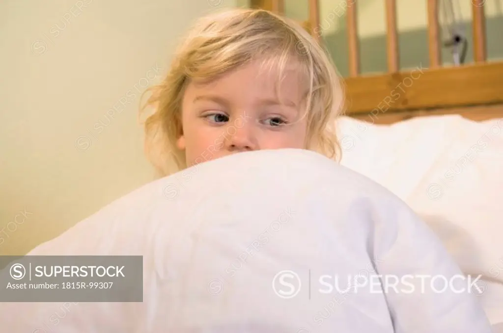 Girl covered with blanket on bed, close up