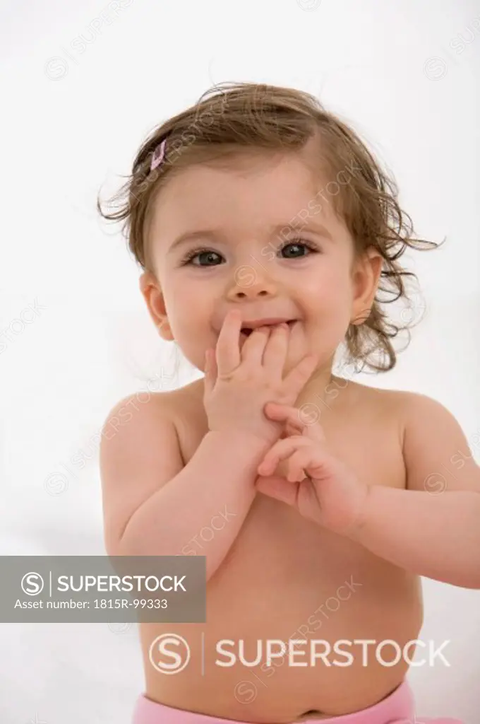 Baby girl with finger in mouth, portrait
