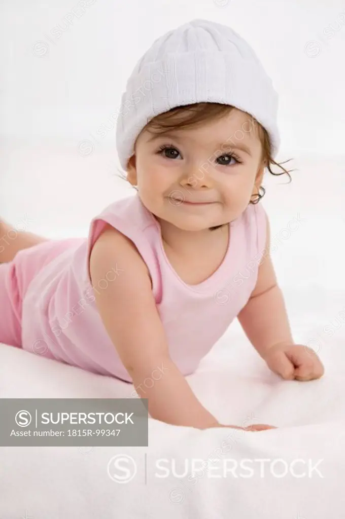 Baby girl lying on baby blanket, smiling