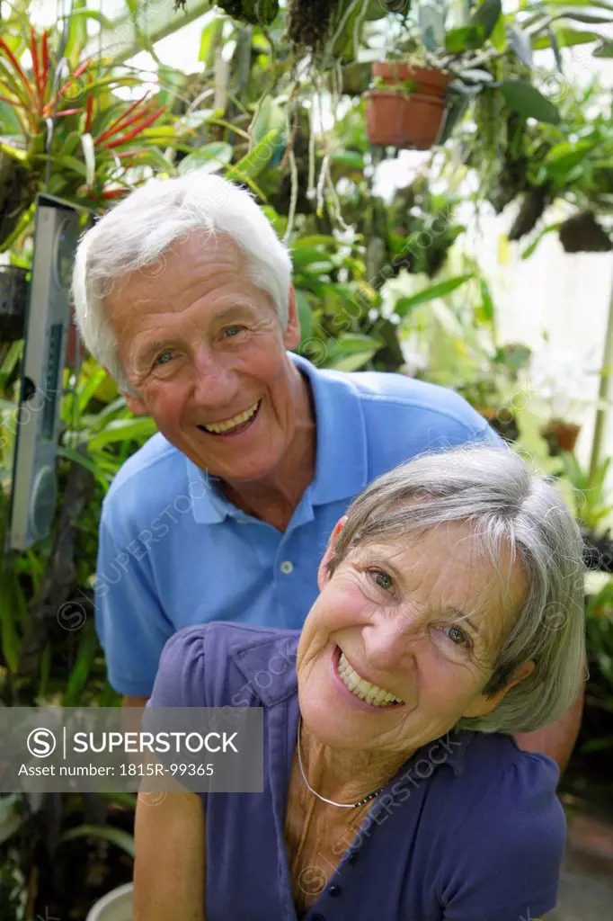 Germany, Bavaria, Senior couple in glass house, portrait