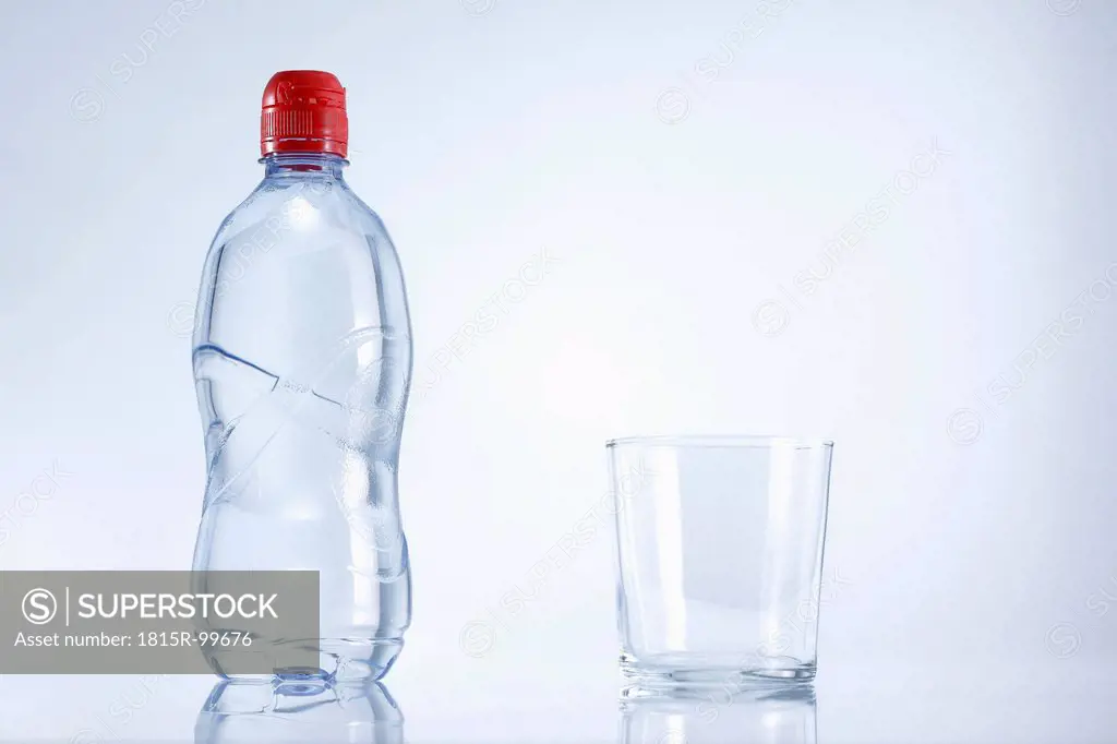 Plastic bottle of mineral water with glass, close up