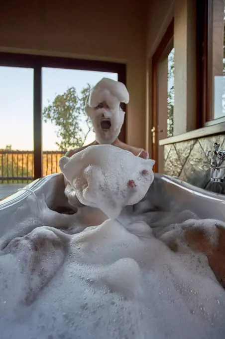 Man playing with the foam in a bathtub