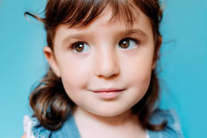 Portrait of cute little girl, blue background